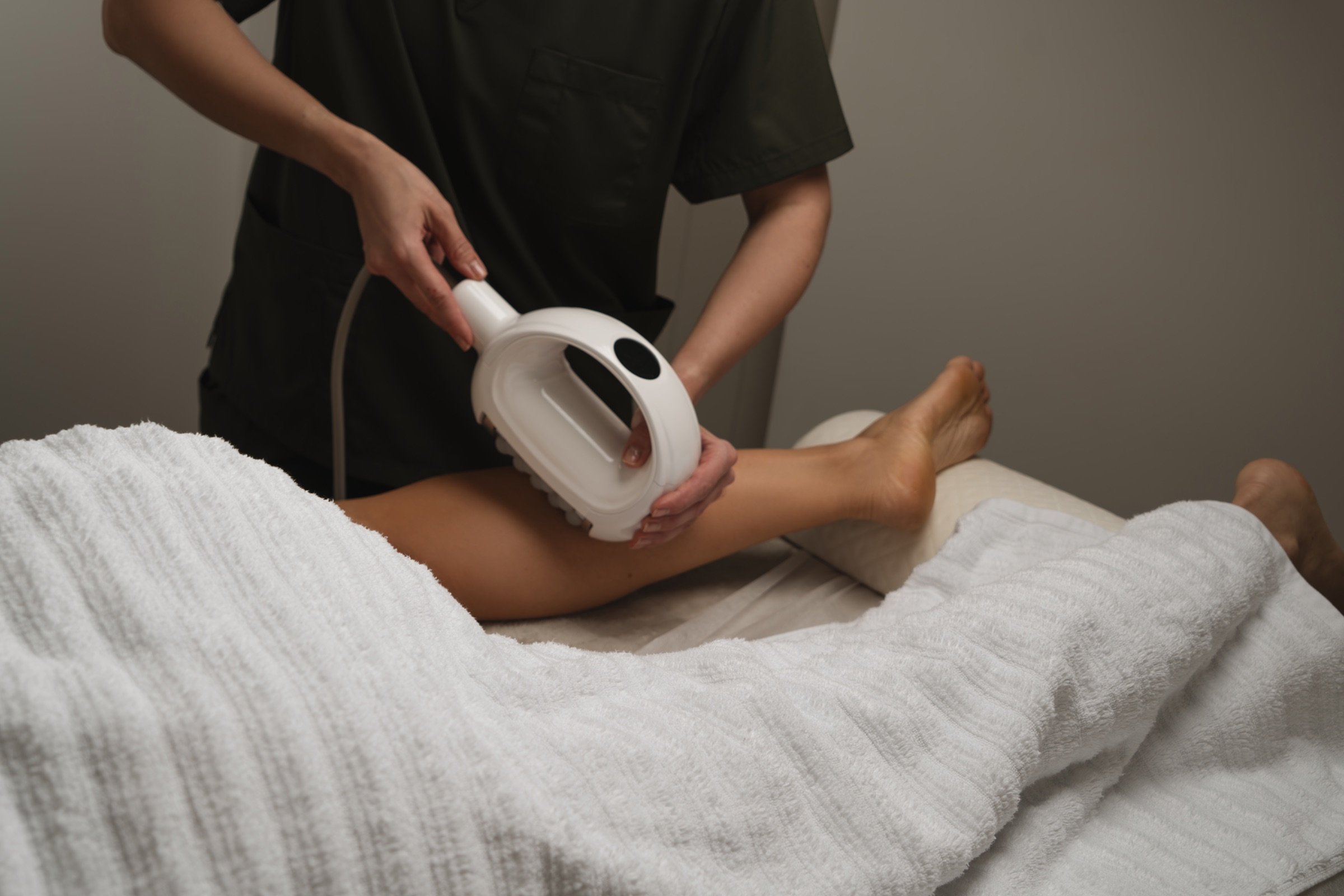 The sphere roller handpiece guided along the leg during a body contouring session