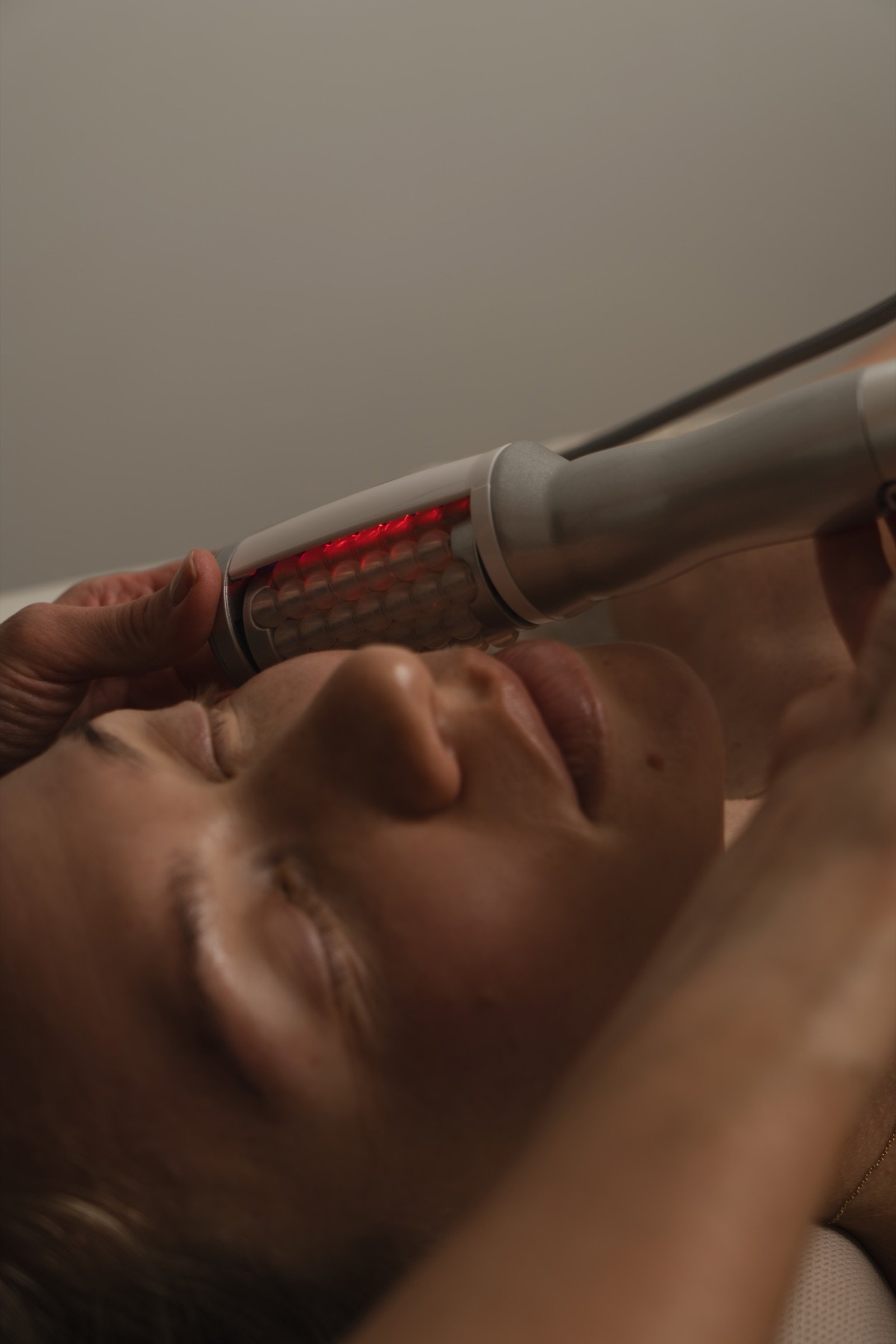 Close-up of the face handpiece gliding along the jawline
