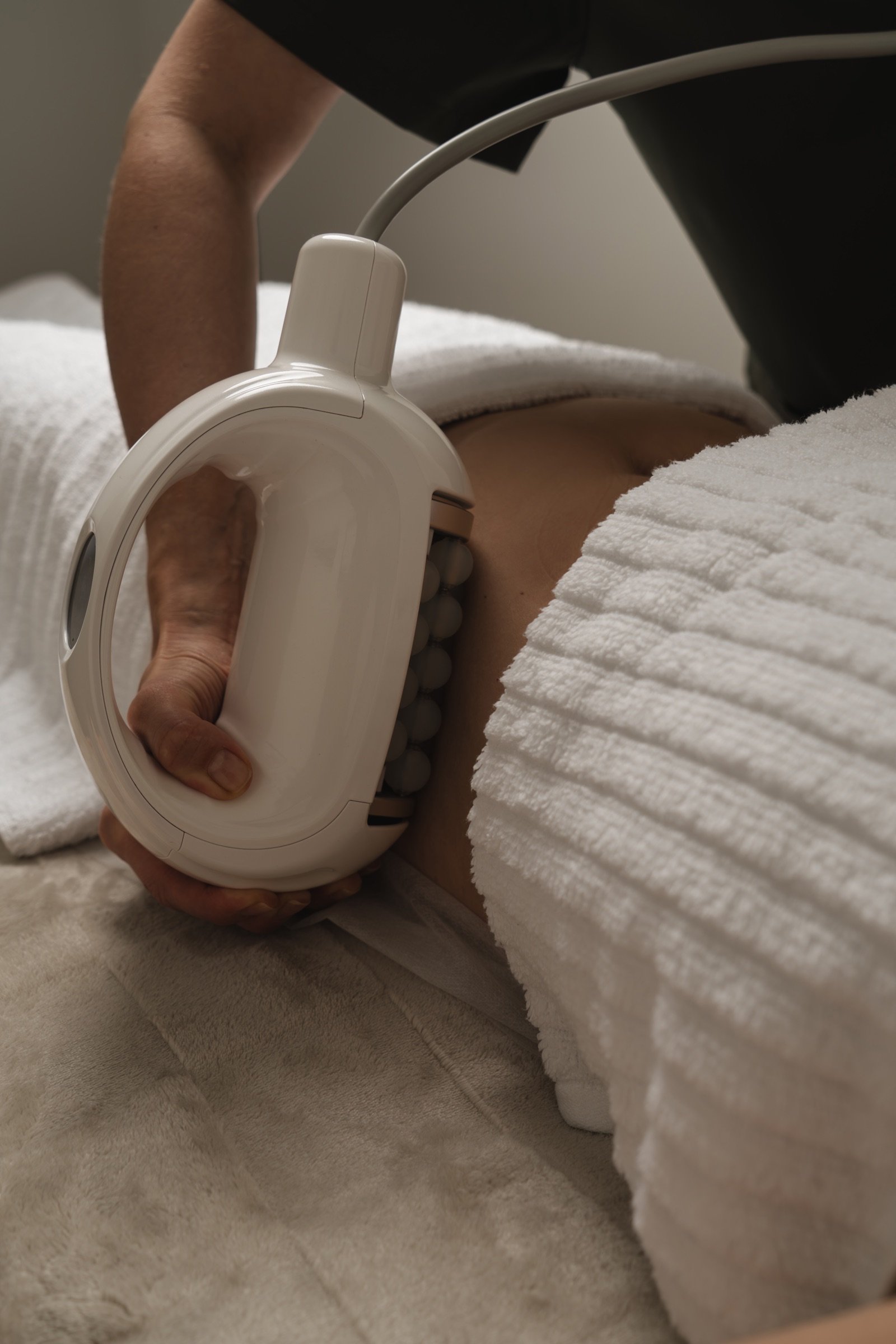 The sphere roller handpiece worked across the hip during a body session